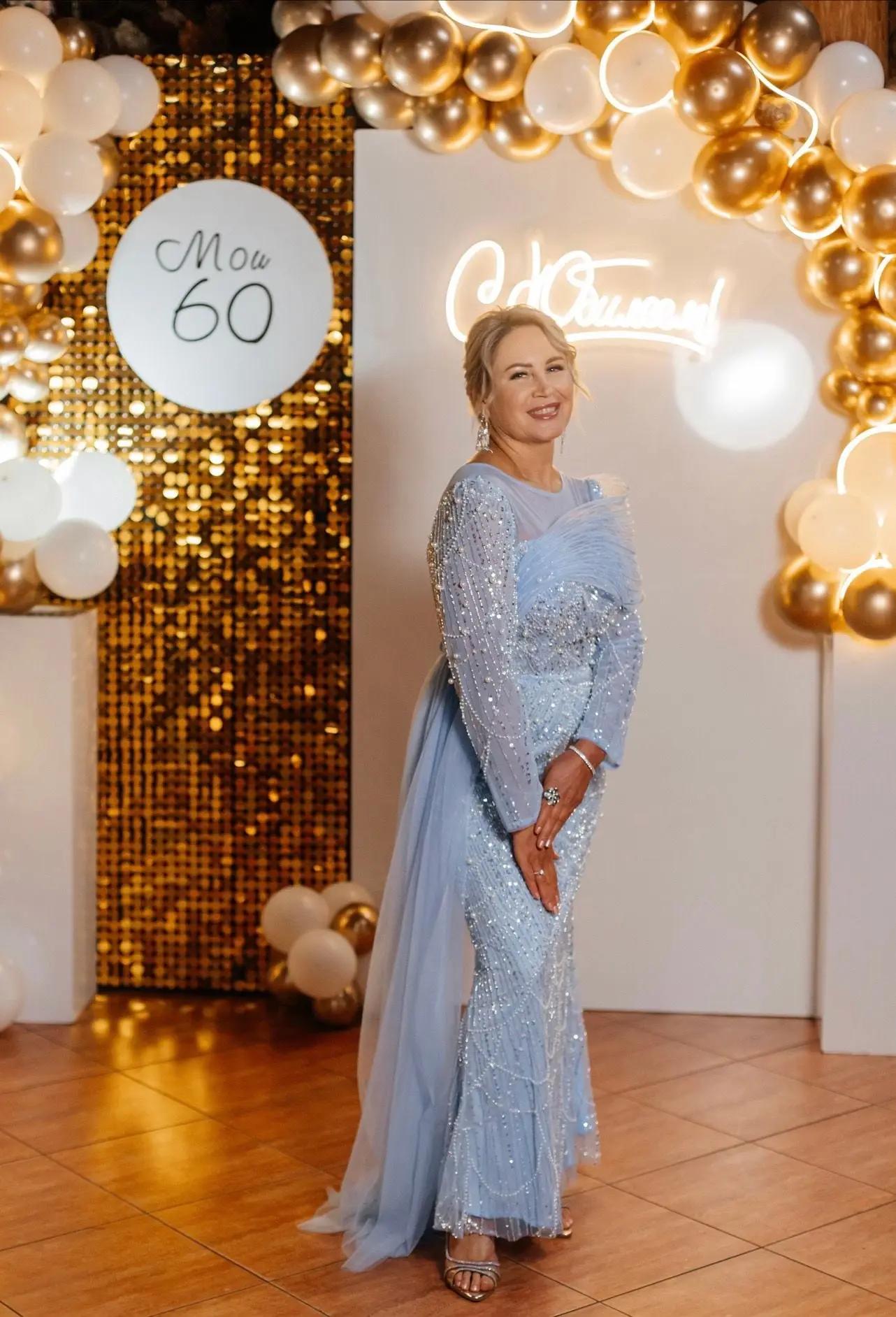 Именинница в голубом платье у стены «Мои 60» с золотыми шарами